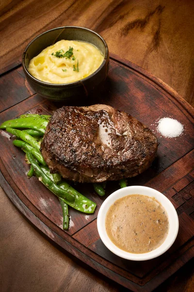 Rib Eye Beef Steak Butter Sauce Gravy Wood Background — Stock fotografie