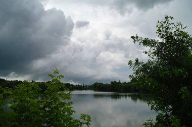 Nehir ve bulutlu gökyüzü olan güzel bir manzara.