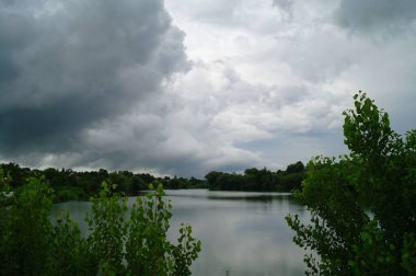 Nehir ve bulutlu gökyüzü olan güzel bir manzara.