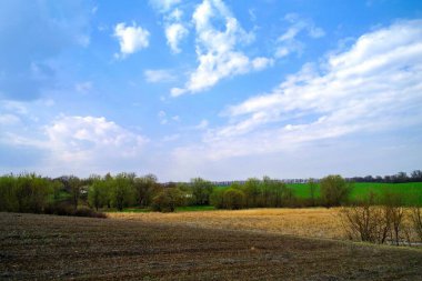 Güneşli bir bahar gününde tarlası olan güzel bir kırsal bölge.