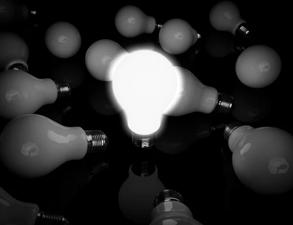 Idea concettuale. Una lampadina incandescente in piedi davanti alla luce spenta — Foto Stock