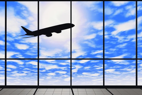 Ventanas del aeropuerto con avión volador —  Fotos de Stock