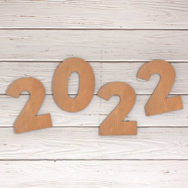 Cardstock Numarası 2022 Mutlu Yıllar tabelası ahşap masa arkasında. 3d Hazırlama