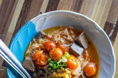 Tayland eriştesi. Pirinç eriştesiyle yemek için baharatlı köri sosu domatesli kıymalı domuz köri, sebzeli pirinç vermicelli. Yerel yemeklerin adı Khanom Jeen Nam Ngiaw..