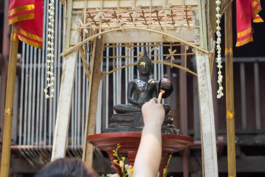 CHIANG MAI, THAILAND 13 Nisan 2022: İnsanlar Chiang Mai, Tayland 'da düzenlenen Songkran Festivali' nde Buda heykeli su seremonisi üzerine su serpiştiriyor.