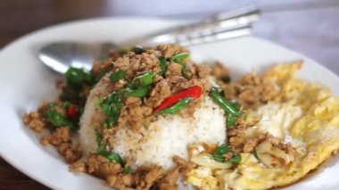 Fesleğen ve kızarmış yumurta ve balık sosuyla karıştırılmış kıymalı domuz eti, Tayland usulü fast food. Tayland sokak yemeği. Tayland 'ın ulusal yemekleri, Tayland' ın adı Pad kra prao Mou.