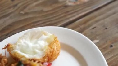 Kızarmış domuz eti, kırmızı köri ezmesi ve fesleğen yaprağı, fasulye ve kızarmış yumurta.