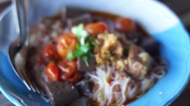 Kuzey Tayland usulü körili pirinç vermicelli. Taylandlı ismi Khanom Jeen Nam Ngeo.