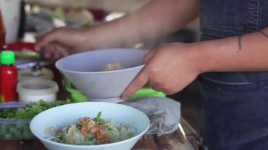 Sıcak erişte tenceresinin üzerinde paslanmaz çelik süzgeç. Akitchen 'de kaynayan buhardan beyaz duman çıkıyor. Tayland sokak yemekleri.