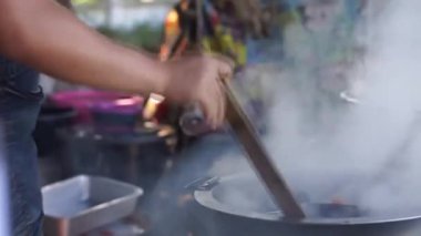 Sıcak erişte tenceresinin üzerinde paslanmaz çelik süzgeç. Akitchen 'de kaynayan buhardan beyaz duman çıkıyor. Tayland sokak yemekleri.