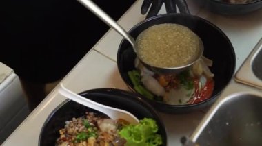 Sıcak erişte tenceresinin üzerinde paslanmaz çelik süzgeç. Akitchen 'de kaynayan buhardan beyaz duman çıkıyor. Tayland sokak yemekleri.