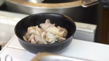 Sıcak erişte tenceresinin üzerinde paslanmaz çelik süzgeç. Akitchen 'de kaynayan buhardan beyaz duman çıkıyor. Tayland sokak yemekleri.