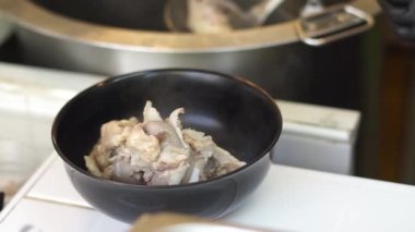 Sıcak erişte tenceresinin üzerinde paslanmaz çelik süzgeç. Akitchen 'de kaynayan buhardan beyaz duman çıkıyor. Tayland sokak yemekleri.