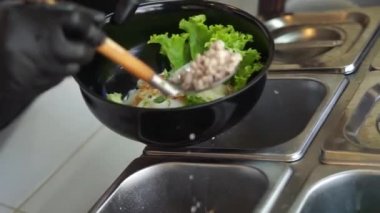 Sıcak erişte tenceresinin üzerinde paslanmaz çelik süzgeç. Akitchen 'de kaynayan buhardan beyaz duman çıkıyor. Tayland sokak yemekleri.