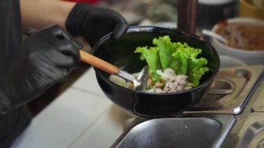 Sıcak erişte tenceresinin üzerinde paslanmaz çelik süzgeç. Akitchen 'de kaynayan buhardan beyaz duman çıkıyor. Tayland sokak yemekleri.