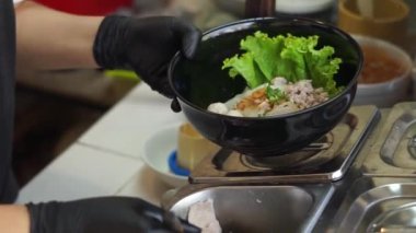 Sıcak erişte tenceresinin üzerinde paslanmaz çelik süzgeç. Akitchen 'de kaynayan buhardan beyaz duman çıkıyor. Tayland sokak yemekleri.
