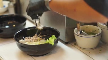 Sıcak erişte tenceresinin üzerinde paslanmaz çelik süzgeç. Akitchen 'de kaynayan buhardan beyaz duman çıkıyor. Tayland sokak yemekleri.