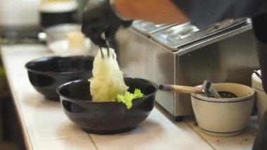 Sıcak erişte tenceresinin üzerinde paslanmaz çelik süzgeç. Akitchen 'de kaynayan buhardan beyaz duman çıkıyor. Tayland sokak yemekleri.