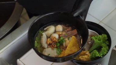 Sıcak erişte tenceresinin üzerinde paslanmaz çelik süzgeç. Akitchen 'de kaynayan buhardan beyaz duman çıkıyor. Tayland sokak yemekleri.