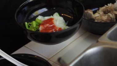 Sıcak erişte tenceresinin üzerinde paslanmaz çelik süzgeç. Akitchen 'de kaynayan buhardan beyaz duman çıkıyor. Tayland sokak yemekleri.