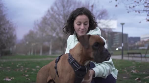 Νεαρή γυναίκα χαϊδεύει το σκύλο της. Σκύλοι και κατοικίδια ζώα έννοια — Αρχείο Βίντεο