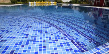 Havuzlu modern villa, bahçe manzaralı. Lüks evin arkasında yüzme havuzu. Balonlar suyun yüzeyinde yatar.