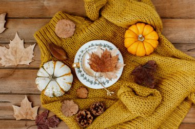 Düz sonbahar, bir kahve fincanı ve ahşap arka planda balkabaklarıyla durgun bir hayat sürüyordu. Şık sonbahar kompozisyonu.