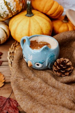 Kahveli sonbahar kompozisyonu, sonbahar yaprakları, ahşap arka planda sıcak süveter ve balkabakları, sonbahar durgun hayatı, sonbahar, sonbahar, Cadılar Bayramı, Şükran Günü konsepti.