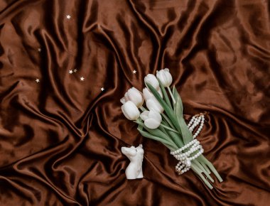 Düz beyaz laleler ve ipek arka planda kadın vücudu şeklinde mumlar vardı. Üst görünüm 