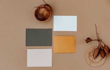 Bej arka planda boş bir kağıt. Ajandalı ve kuru yapraklı ofis masası çalışma alanı. Düğün davetiyesi. Düz yatış, boş kopyalama alanı olan üst görünüm modeli