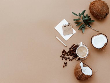 Masaüstü model planlayıcısı. Takvim, boş kart, kahve fincanı ve kahverengi arkaplanda yeşil zeytin yapraklarıyla yatıyordu. Sıfır atık, çevre dostu, doğal organik konsept.