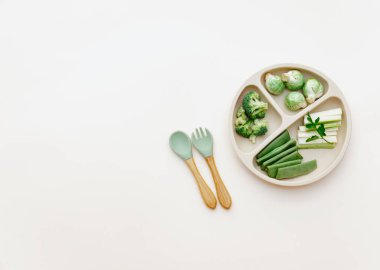 Bebek maması düzdü. Taze yeşil sebze çeşitleri. Vitaminli, mineralli sağlıklı vejetaryen yemekleri. İlk çocuk beslenme konsepti. Üst görünüm