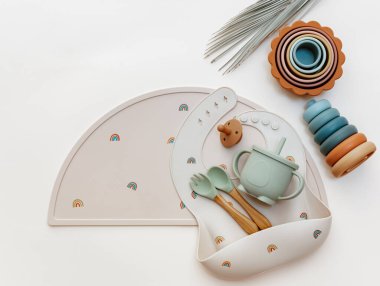 Pastel silikon masa takımı, önlük, aksesuar mavi arka plandaki çocuklar için Montessori oyuncakları. Bebek aksesuarları, sofra takımı konsepti.