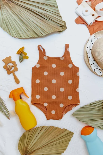 Çocuk oyuncakları ve plaj aksesuarlarıyla bir şişe güneş kremi. Çocuklar için cilt bakımı ve koruma konsepti. Düz yatış, üst görünüm 