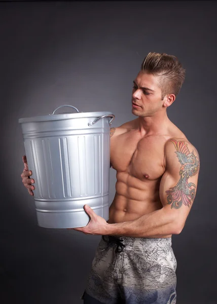 Uomo muscolare con spazzatura — Foto Stock