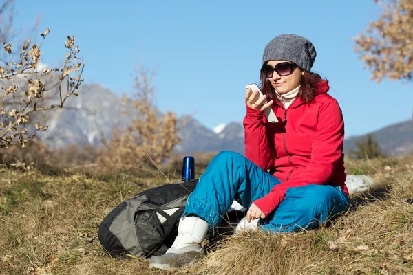 Женщина-туристка с мобильного телефона на вершине горы — стоковое фото