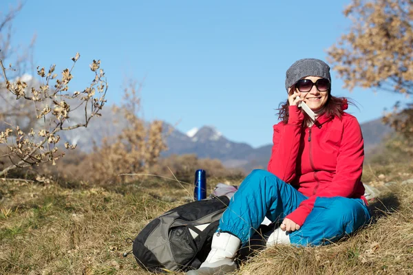 Vrouwelijke wandelaar met behulp van mobiele telefoon ontop van berg — Stockfoto