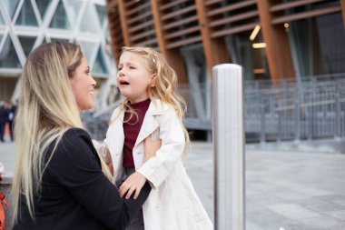 Genç kadın ağlayan kızıyla ilgilenir.