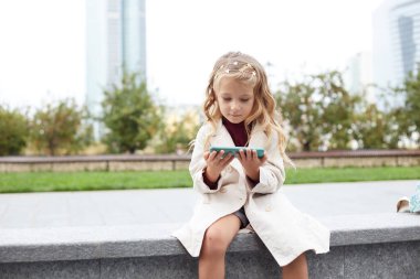 Uzun saçlı, cep telefonu olan komik çocuk.