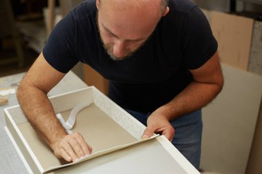 Bir atölyede çalışan kitap klasörü