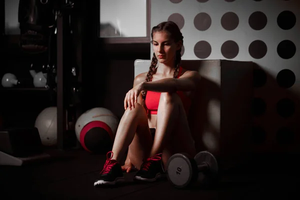 ワークアウトの後 床に座って見下ろしている若い女性 フィットネストレーニング後に休息する女子アスリート — ストック写真
