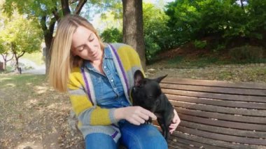 Sonbaharda Fransız Bulldog 'u olan mutlu genç bir kadın.