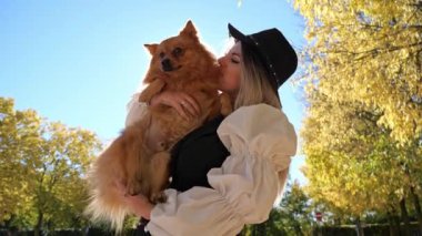 Kız kırmızı Pomeranya köpeğiyle oynuyor