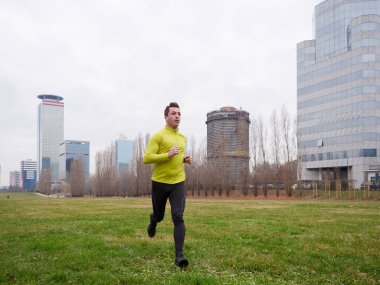 Yetişkin Adam kışın şehir planıyla parkta koşuyor