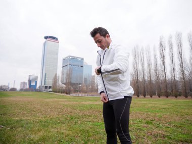 Yetişkin Adam kışın şehir planıyla parkta koşuyor