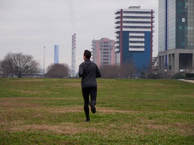 Yetişkin Adam kışın şehir planıyla parkta koşuyor