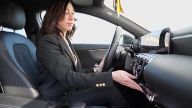 Güzel bir kadın arabanın klimasını ayarlar.
