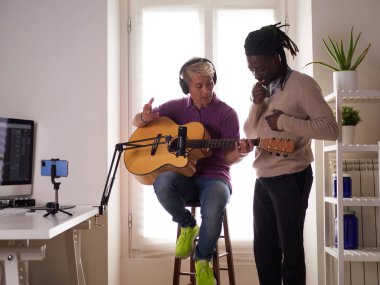 Kişisel bir Afroamerikalı öğretmen Asyalı öğrencisine akoru doğru bir şekilde nasıl çalacağını anlatıyor. Evde müzik eğitimi