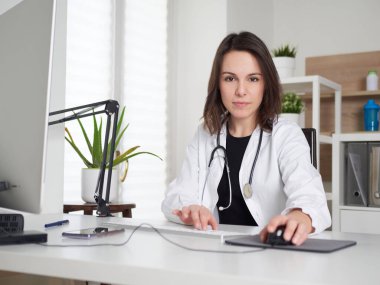 Ofis masasında çalışan kadın doktor.