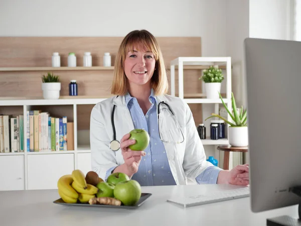 女性栄養士オフィススタジオで緑のリンゴを保持 — ストック写真